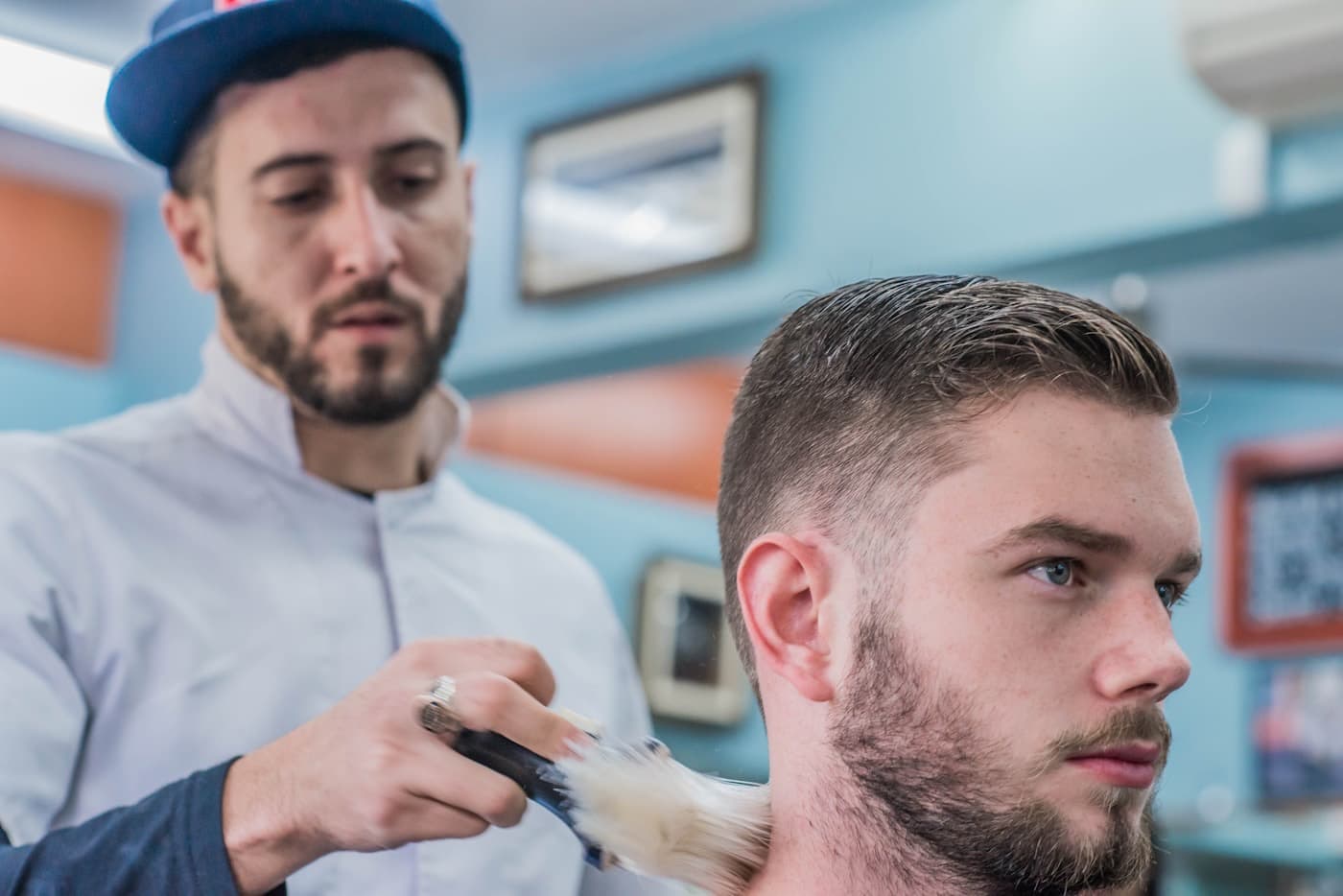 Barber dusting off a finished cut with a neck brush