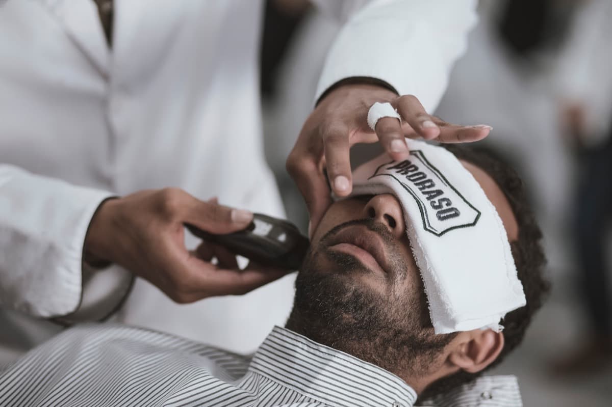 Hot towel laid over a customer's face before a straight razor shave